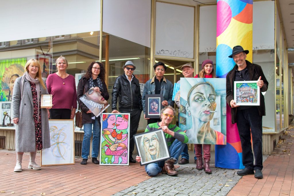 Künstler posieren vor dem Eingang des Kulturladenhörde